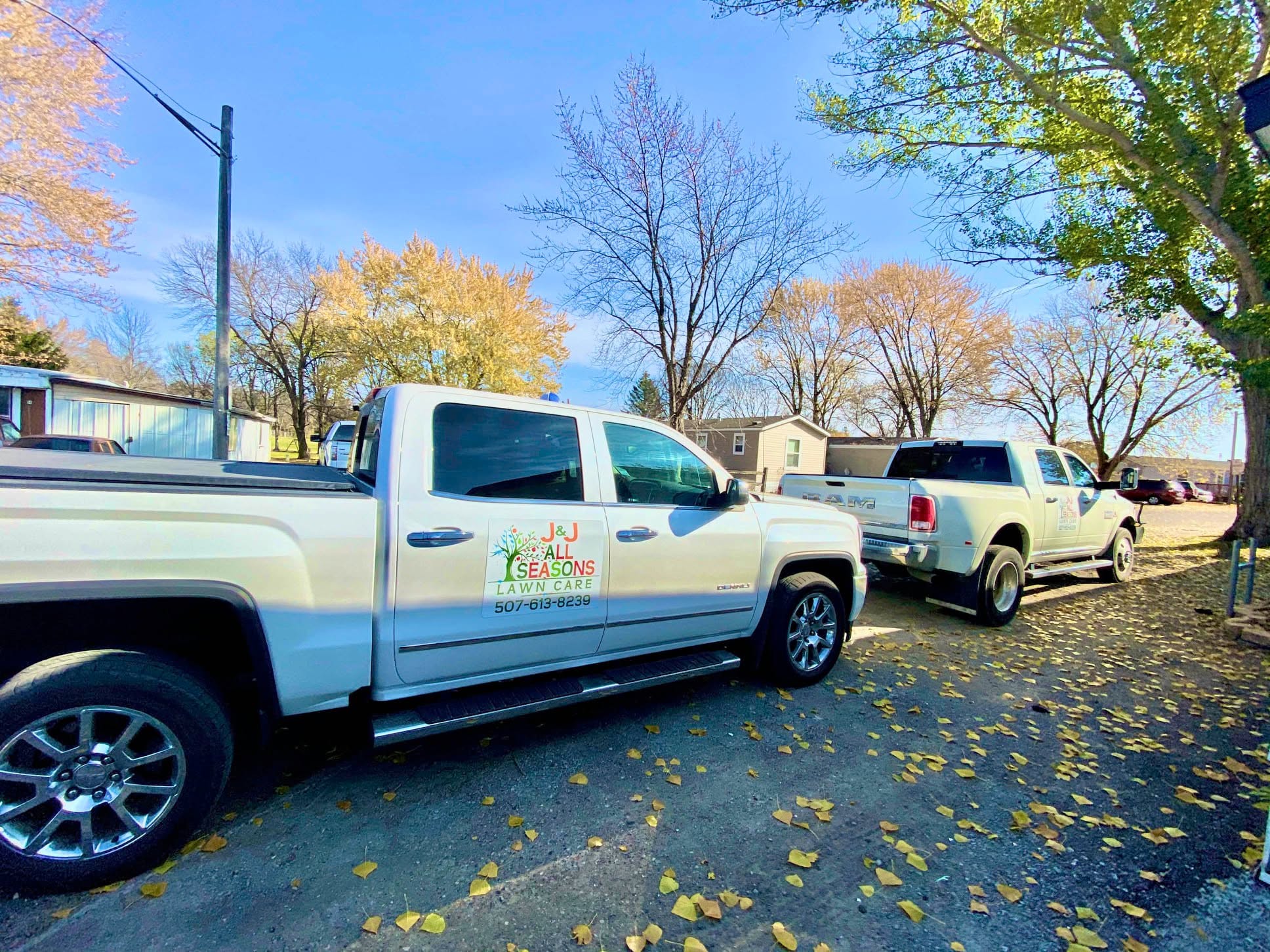 J&J All Seasons Lawn Care branded trucks parked and ready for service